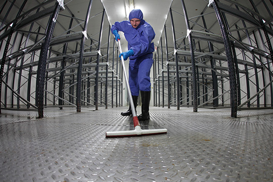 Man in blue overalls mopping floor